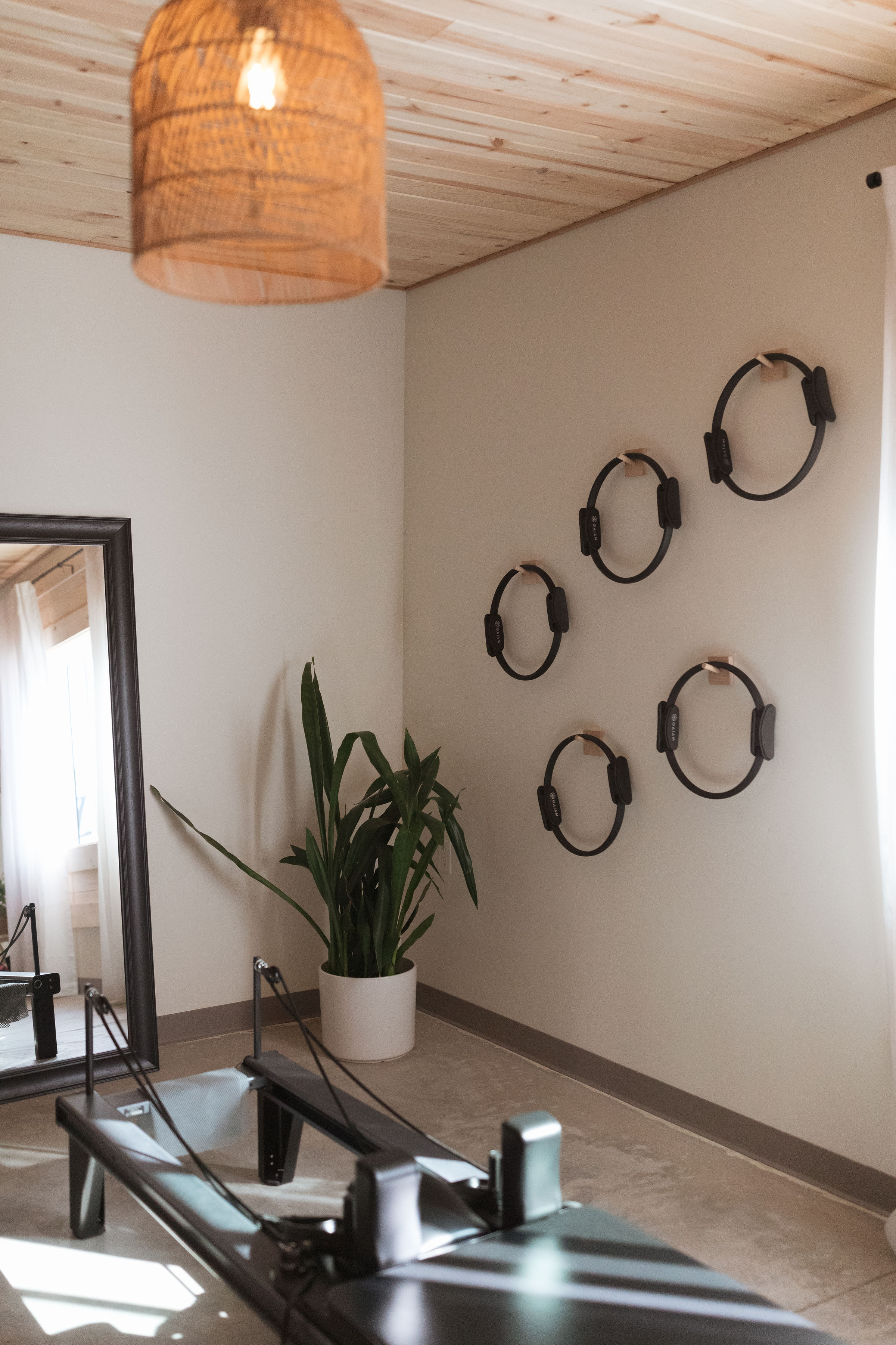 Sunlit Yavu studio with reformers, Pilates rings, plants, and warm woven lighting